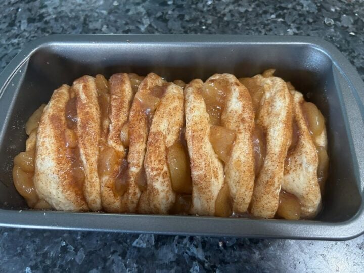 risen dough in pan with caramel apples