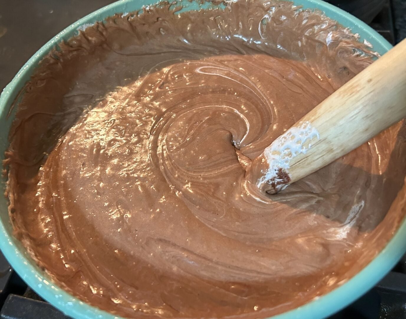 adding marshmallow cream to bowl of fudge