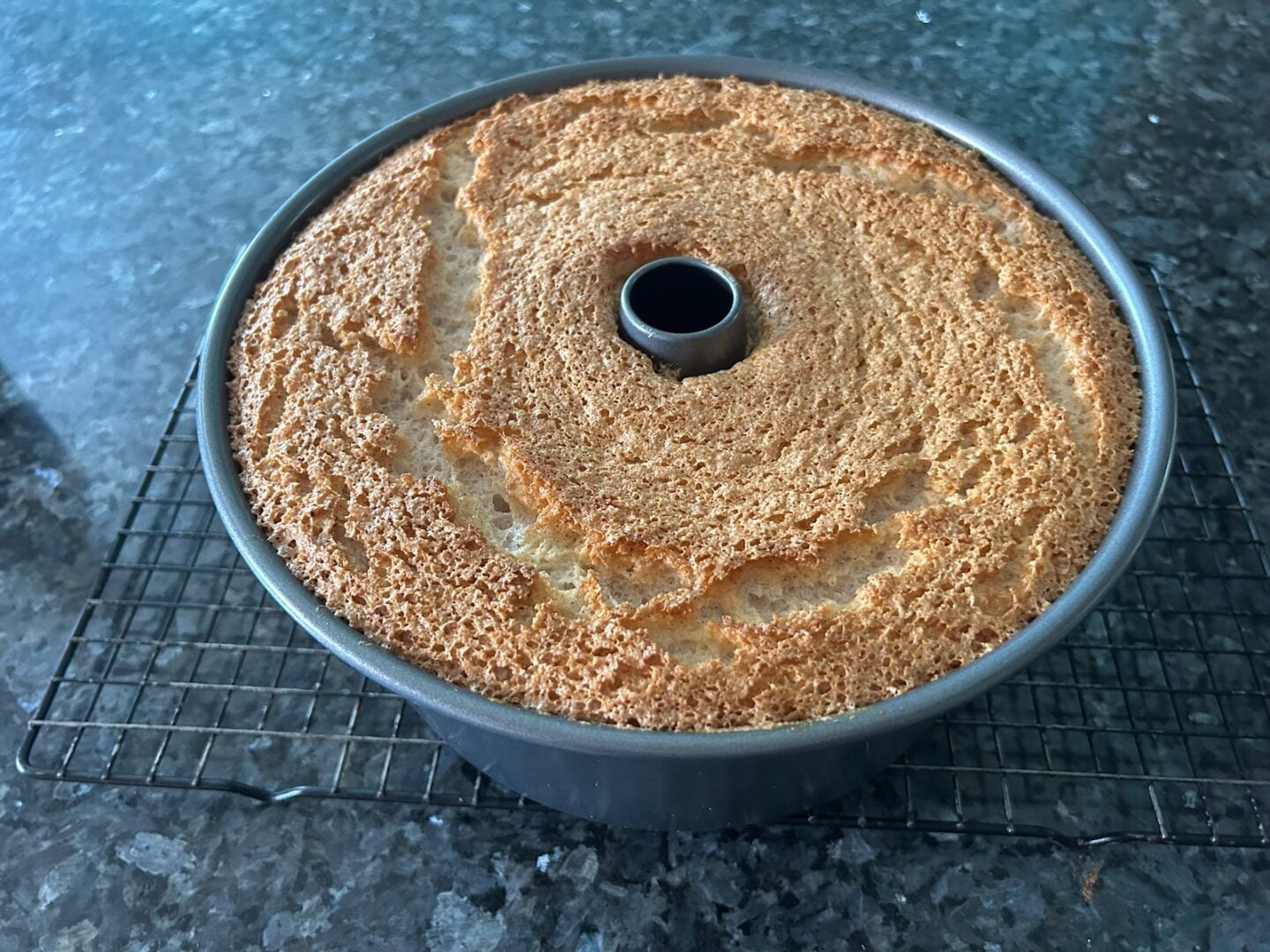 baked snickerdoodle angel food cake in pan cooling