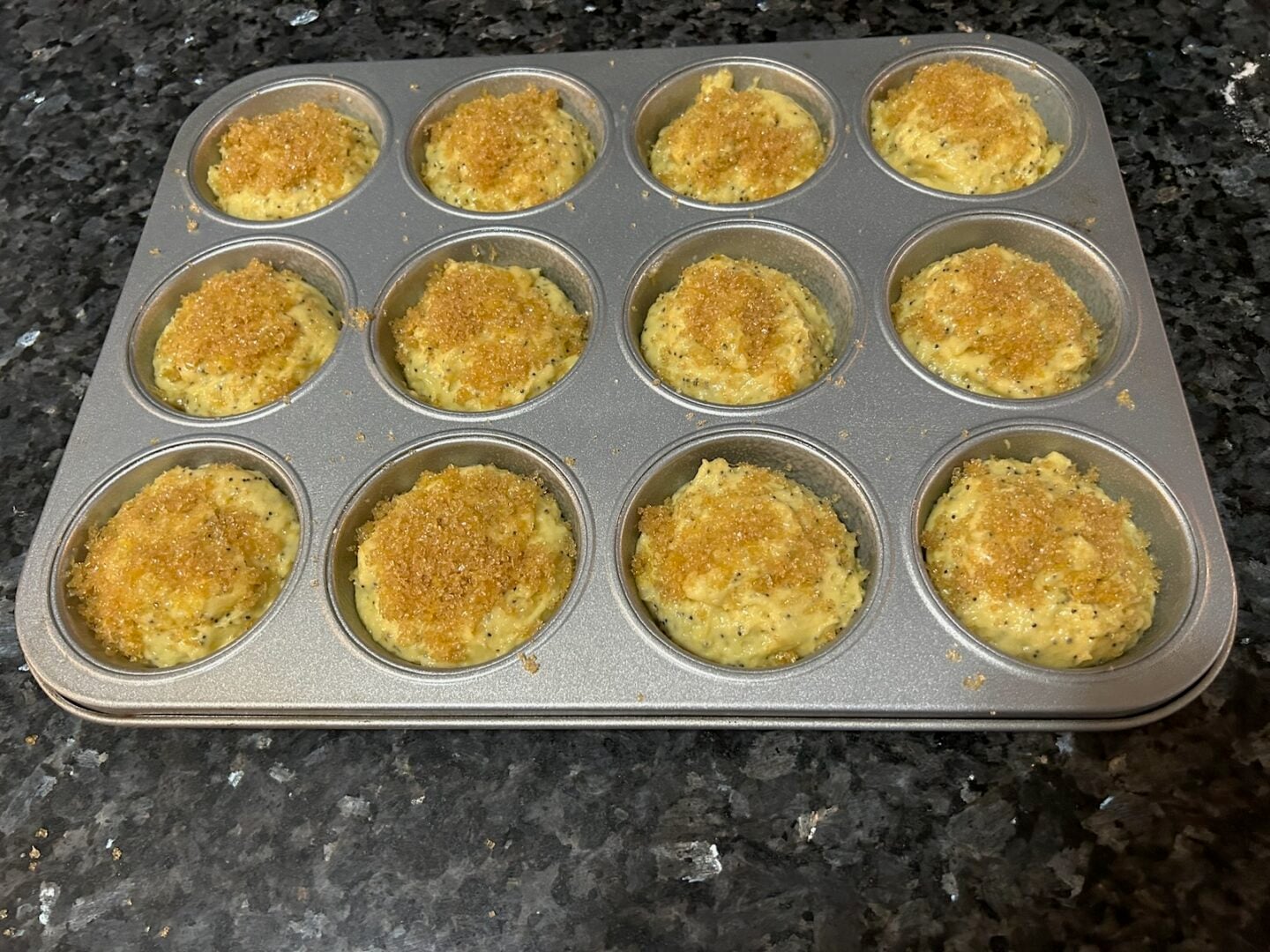lemon sugar on lemon muffin batter in pan